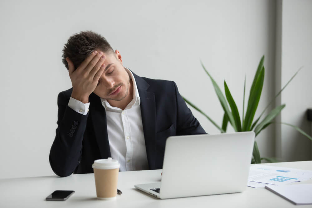 frustrated-millennial-businessman-having-strong-headache-tired-from-laptop-work